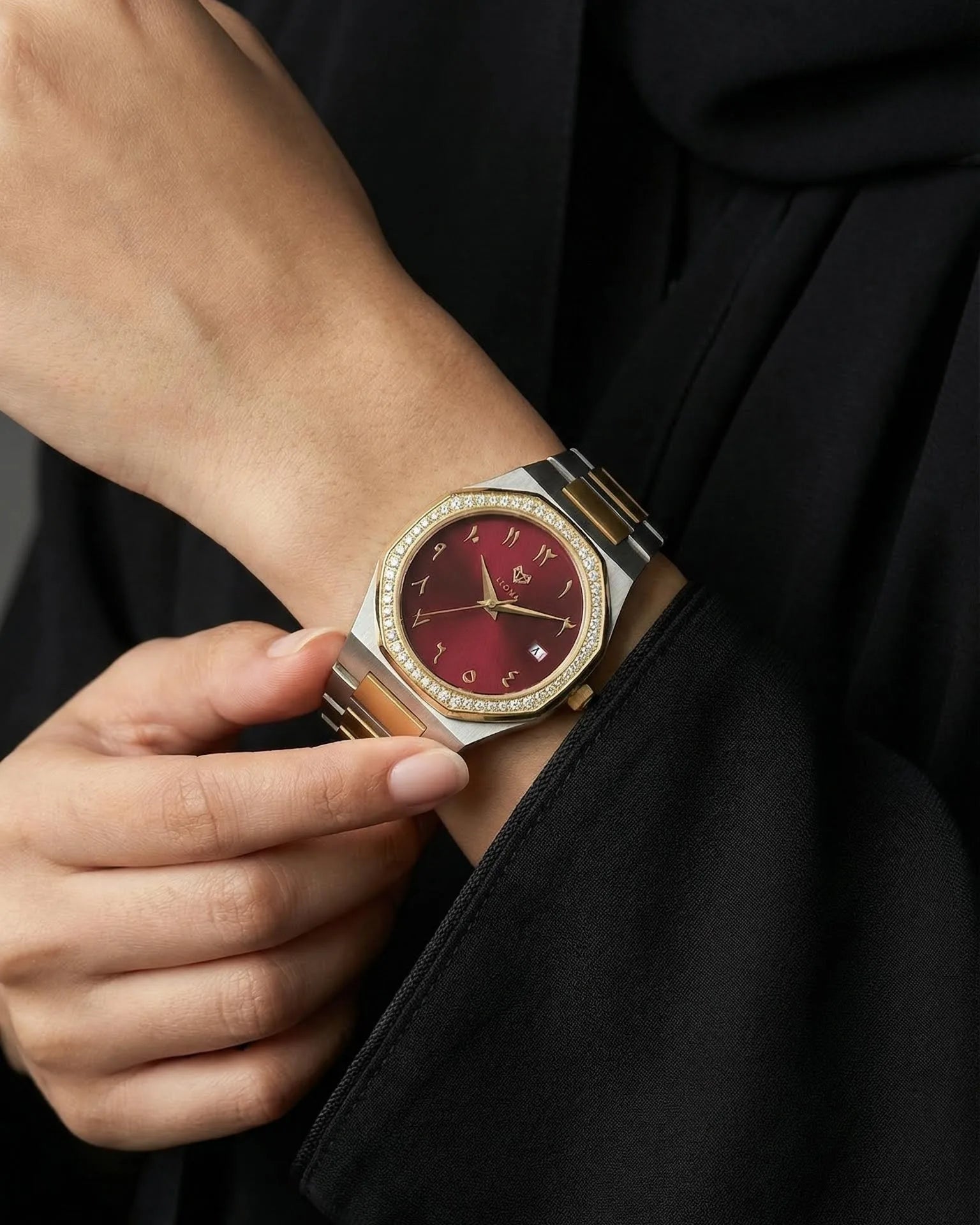 Luxury watch with a red face on a person's wrist against a black background