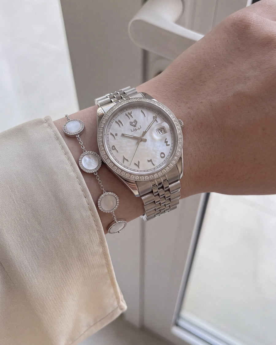 Perla White watch and mother-of-pearl bracelet worn with a black abaya