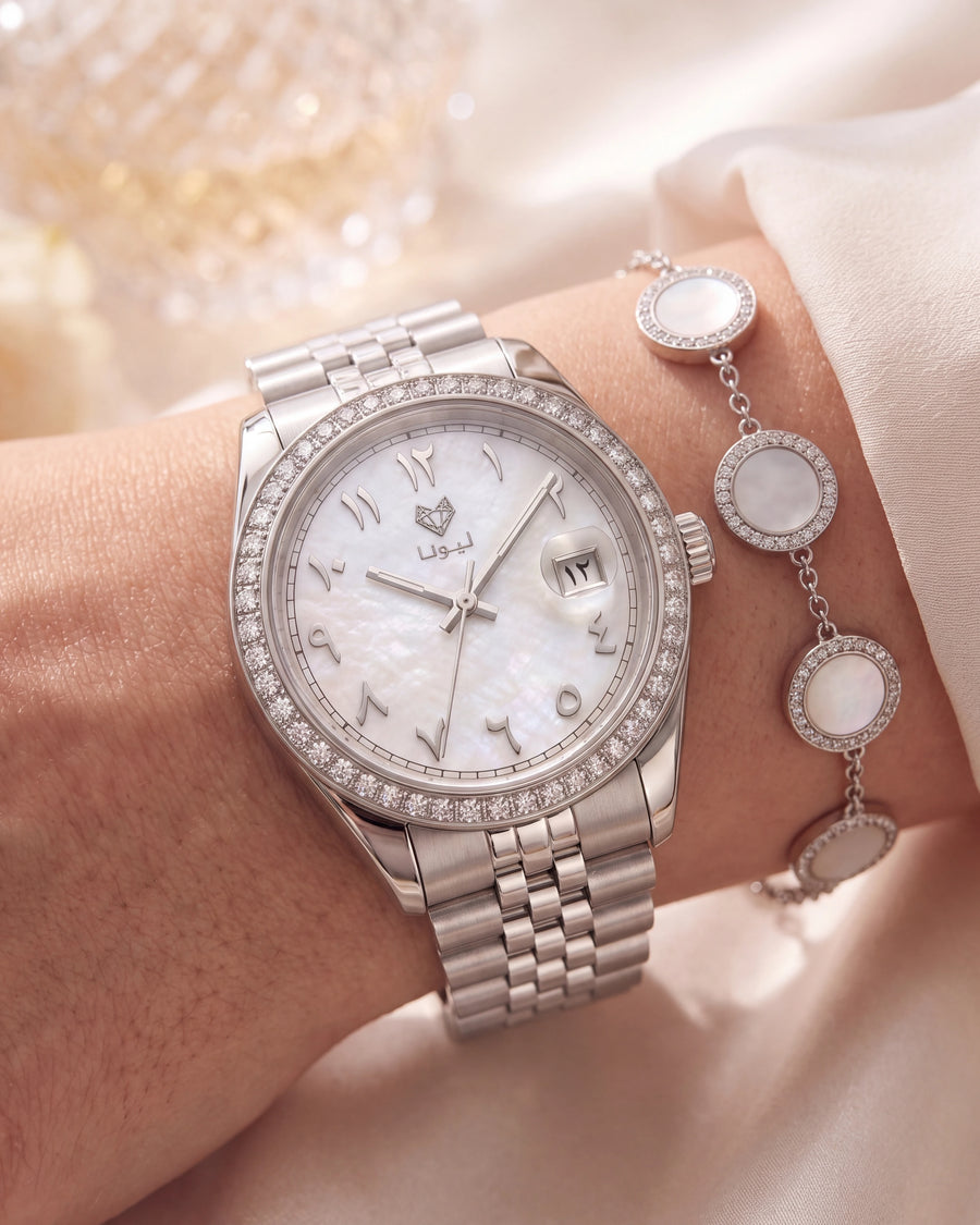 Close-up of the Perla White watch and four-disc mother-of-pearl bracelet on ivory satin