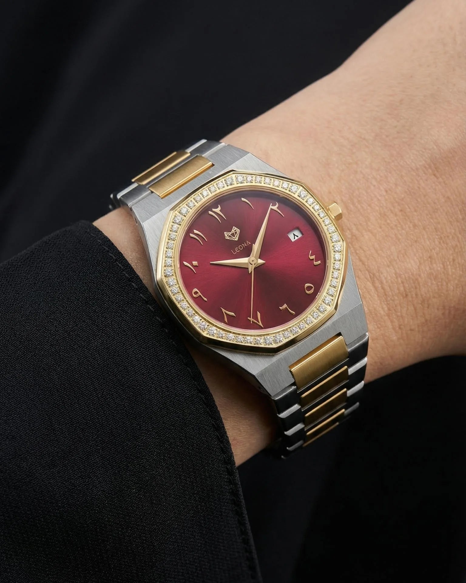 Luxury watch with red arabic face and gold accents on a wrist against a dark background